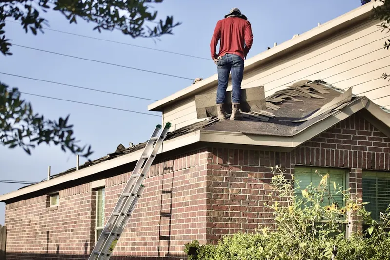 Professional roofer working on a residential roof in Towne Mall